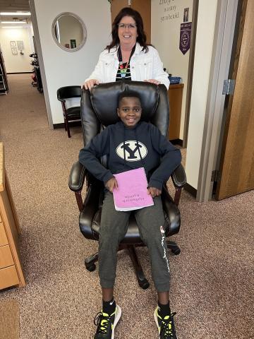 Mrs. Taylor helping King with the principal's chair.